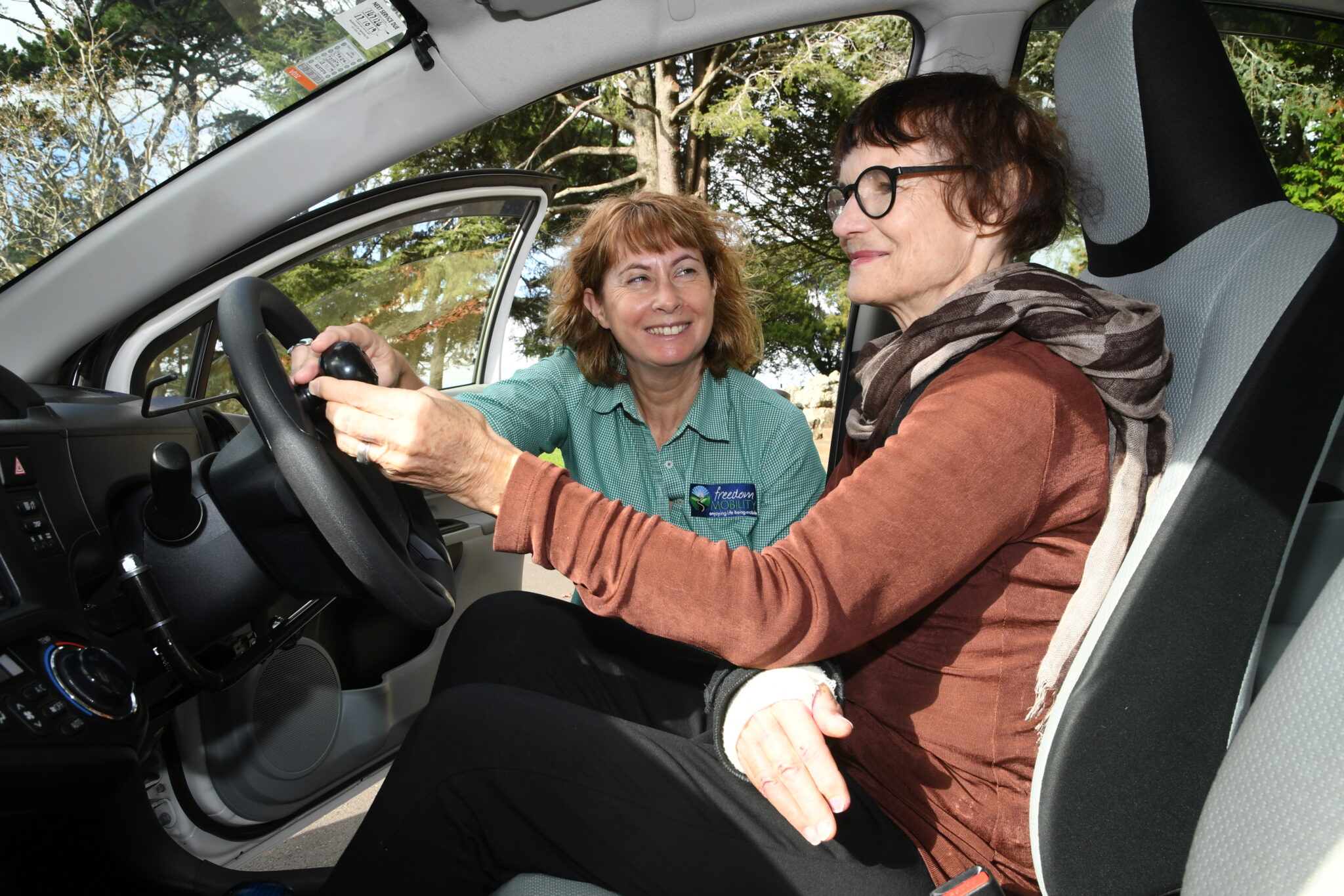 Ange Bates, mobility driving instructor, shows a client the features of a Hand Control Car