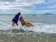 BeachWheelchairFunWaipuCove 240x180 - Accessible Beach - Waipu Cove Beach